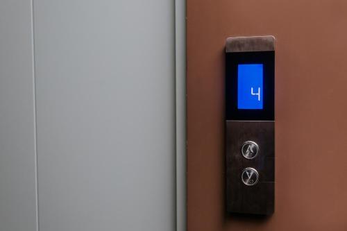 a digital clock on a wall next to a door at Madina-ZamZam Halal Hotels Group in Baku