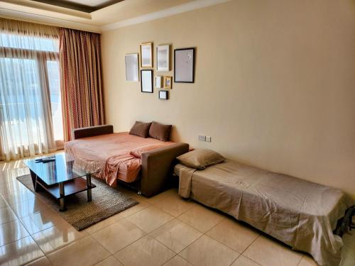 een woonkamer met 2 bedden en een tafel bij Seafront Apartment - Wifi - Sleeps 6 - ChrisCourt in Marsaskala