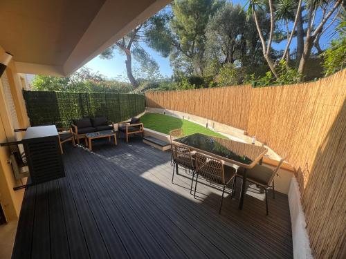 a deck with chairs and tables and a fence at Papillon de cimiez in Nice