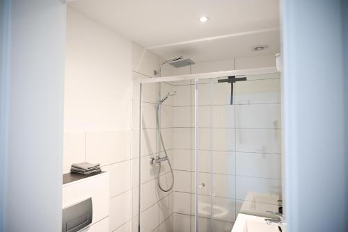 a white bathroom with a shower and a sink at ZENITH STAY - hochwertige Apartments direkt in der Innenstadt in Erkelenz