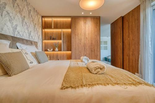 a bedroom with a large white bed with a largeermott at Appartement de luxe - Aux portes de Paris in Saint-Mandé