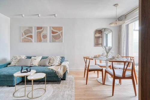 ein Wohnzimmer mit einem blauen Sofa und einem Tisch in der Unterkunft Appartement de luxe - Aux portes de Paris in Saint-Mandé