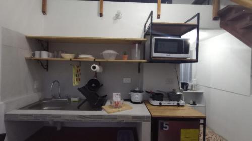 a small kitchen with a sink and a microwave at LA CASITA DE PUEBLO NUEVO in Puerto Limón