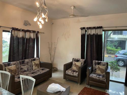 a living room with couches and chairs and a table at Samruddhi S3 homestay garden villa or S1 in Nagpur