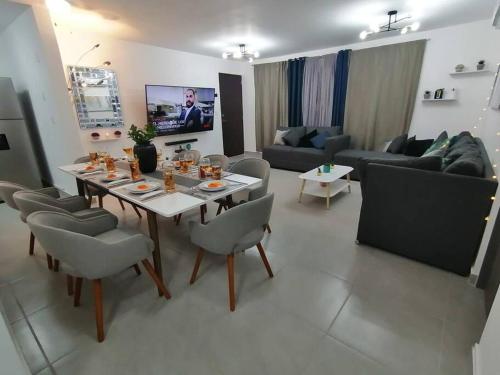a living room with a table and chairs and a couch at Depto. frente al mar con Club de Playa in Acapulco