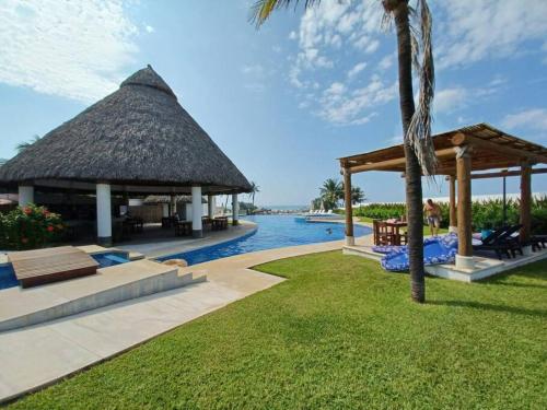 um resort com uma piscina e um gazebo em Depto. frente al mar con Club de Playa em Acapulco