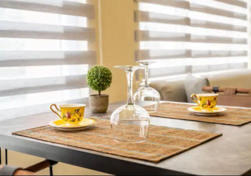 einen Tisch mit zwei Gläsern und zwei Tassen drauf. in der Unterkunft Osmanbey’de geniş stüdyo daire in Istanbul