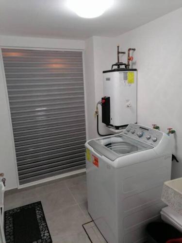 a kitchen with a machine in the corner of a room at Depto. frente al mar con Club de Playa in Acapulco