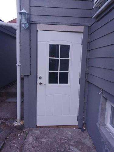 a white garage door with a window on a house at koselig kjellerleilighet near sentrum in Moss