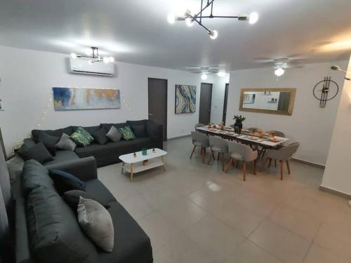 a living room with a couch and a dining table at Depto. frente al mar con Club de Playa in Acapulco