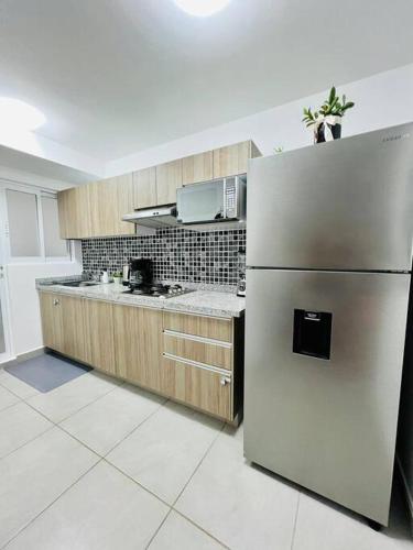 a kitchen with a stainless steel refrigerator at Depto. frente al mar con Club de Playa in Acapulco