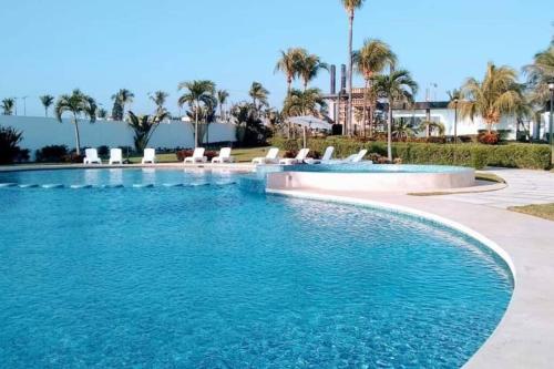 a swimming pool with blue water in a resort at Depto. frente al mar con Club de Playa in Acapulco