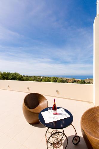a table with a bottle of wine on a balcony at Villa Victoria in Gállos
