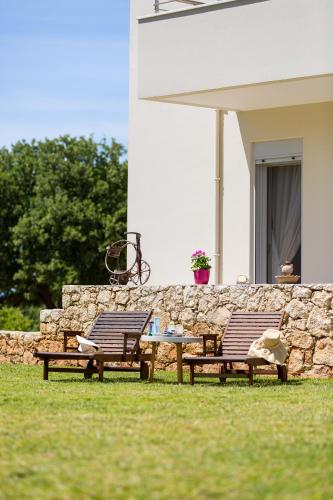 two chairs and a table in front of a stone wall at Villa Victoria in Gállos