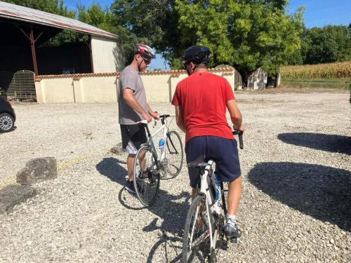 Twee mannen staan met hun fietsen op een parkeerplaats. bij Les Cygnes Noirs in Aujac