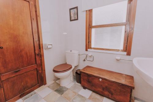 a bathroom with a toilet and a sink and a wooden door at Casa Marita 11 in Los Llanos de Aridane