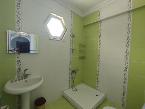 a green bathroom with a sink and a toilet at Large House in Trabzon