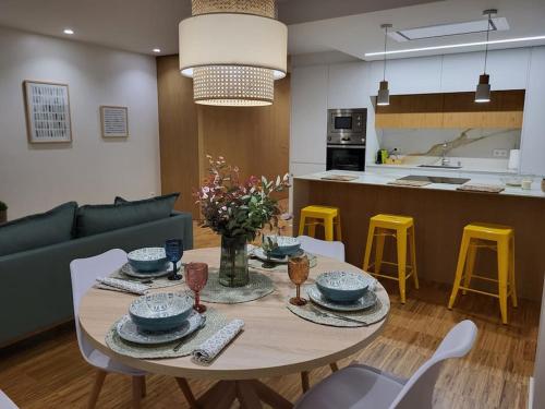 einen Esstisch mit Stühlen und eine Küche in der Unterkunft O 3 de Monteferro in Nigrán