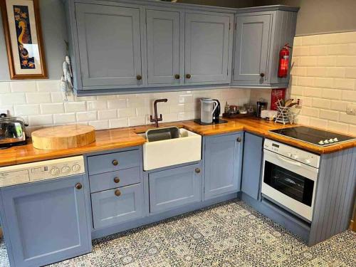 una cocina con armarios azules y fregadero en Castle View Suite, en Sligo