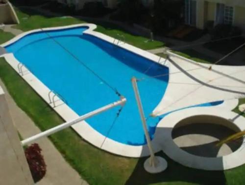 a blue swimming pool with a pole next to it at EXCELENTE Depa en Acapulco Diamante FRENTE AL MAR! in Acapulco