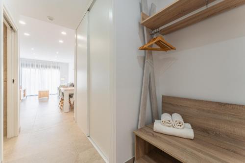 a hallway with white walls and white shoes on a bench at CMDreams Platinium- Apartamentos turísticos en el centro de Mérida in Merida