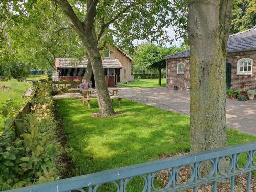 a park with a bench and trees and a building at B&B De NieuwenHof 'De Voorkamer' in Melderslo