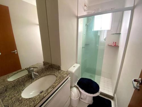 uma casa de banho com um lavatório, um chuveiro e um WC. em 3 Quartos vila velha Praia de Itaparica em Vila Velha