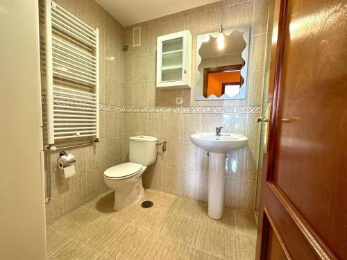a bathroom with a toilet and a sink at La Piragua in Ribadesella