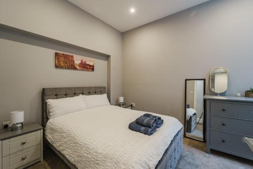 a bedroom with a bed and a dresser and a mirror at Augusta House - Moseley in Birmingham