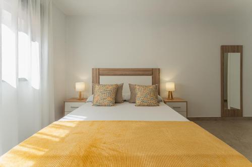 a bedroom with a bed with a yellow blanket on it at CMDreams Platinium- Apartamentos turísticos en el centro de Mérida in Merida