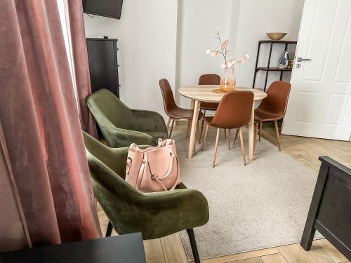 ソポトにあるSopot blisko plaży 4のテーブルと椅子、ピンクの袋が備わる客室です。