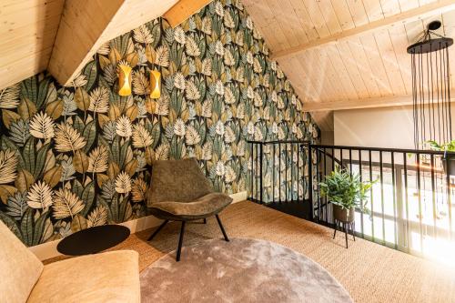 a living room with a flowery wallpaper on the wall at B&B De NieuwenHof 'De Tuinkamer' in Melderslo