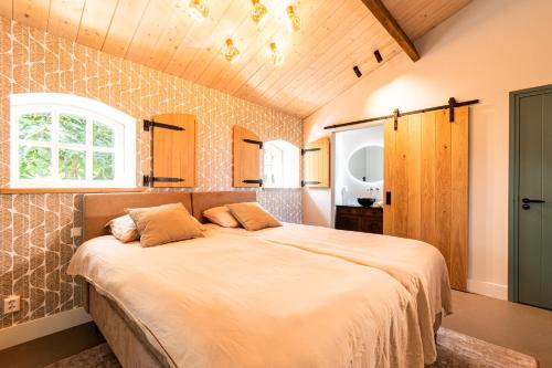 1 dormitorio con 1 cama grande en una habitación en B&B De NieuwenHof 'De Tuinkamer' en Melderslo