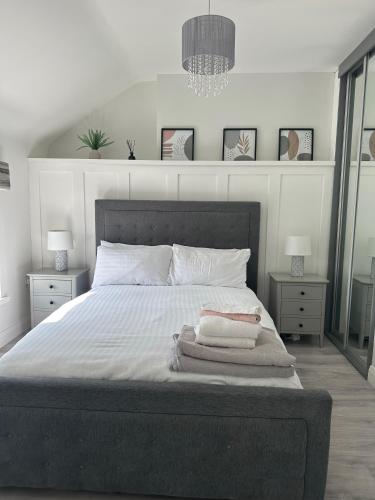 Westland Suites - Stylish, Modern, Elegant, Central Apartments A في ديري لندنديري: غرفة نوم بسرير كبير مع مواقف ليلتين