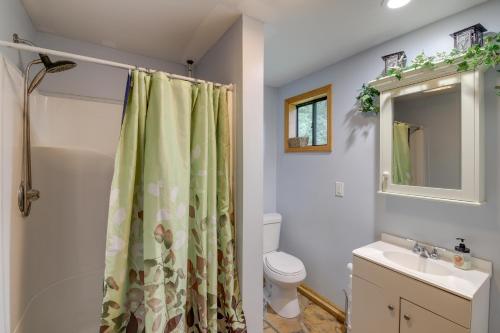 Un baño con cortina de ducha y un inodoro. en Riverfront Briceville Cabin with Patio and Fire Pit!, en Briceville