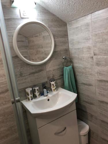 La salle de bains est pourvue d'un lavabo et d'un miroir. dans l'établissement Apartmani Kaić, à Livno