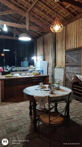 a kitchen with a table in the middle of a room at Rancho de Vidro no Paraíso in Pederneiras