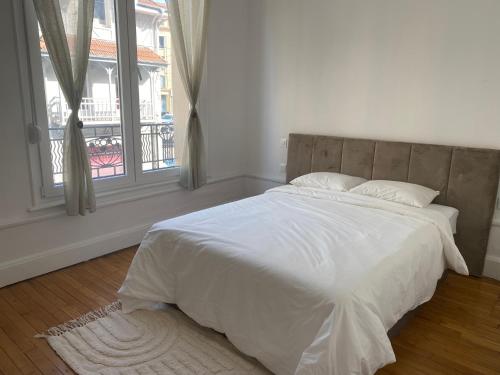 a bedroom with a bed with white sheets and a window at Appart hyper-centre, à 5 min à pieds de la gare in Longwy