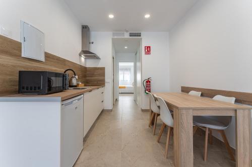 a kitchen with a wooden table and a dining room at CMDreams Platinium- Apartamentos turísticos en el centro de Mérida in Merida