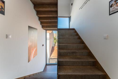 a staircase in a house with white walls and wooden floors at CMDreams Platinium- Apartamentos turísticos en el centro de Mérida in Merida