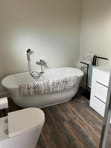 uma casa de banho com uma banheira branca e um WC. em Lakeside Lodge em Eastleigh