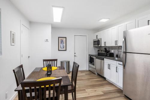 a kitchen with a table with chairs and a refrigerator at Harbourside Flats in Fort Lauderdale