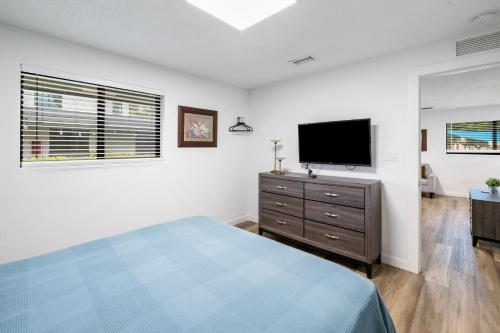 a bedroom with a bed and a flat screen tv at Harbourside Flats in Fort Lauderdale