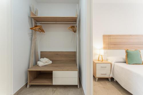 a small bedroom with a bed and a desk at CMDreams Platinium- Apartamentos turísticos en el centro de Mérida in Merida