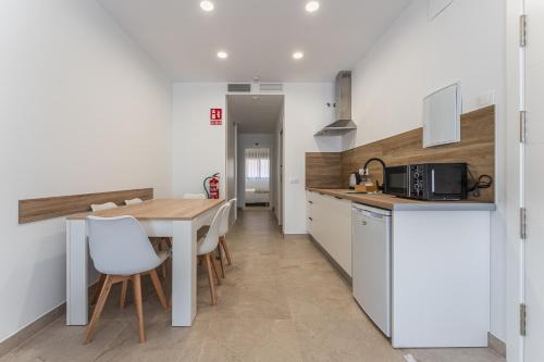 a kitchen and dining room with a table and chairs at CMDreams Platinium- Apartamentos turísticos en el centro de Mérida in Merida
