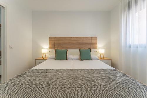 a bedroom with a large bed with two green pillows at CMDreams Platinium- Apartamentos turísticos en el centro de Mérida in Merida