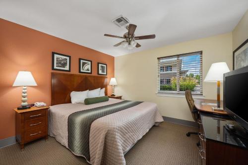 a hotel room with a bed and a ceiling fan at Affordable Suites of America Stafford Quantico in Stafford