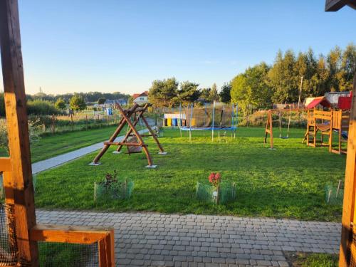 a park with a playground with a swing set at Domki Letniskowe U Żuni in Chłopy