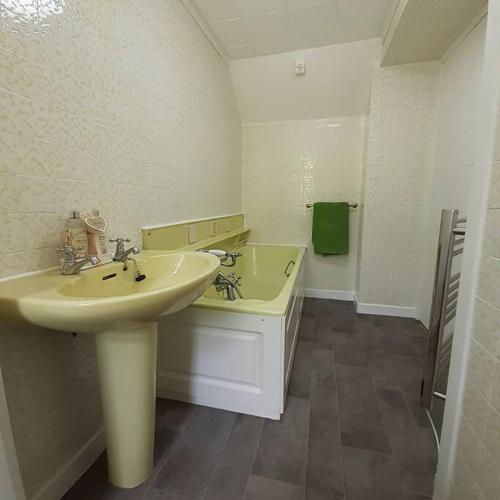 a white bathroom with a sink and a tub at Peaceful and Stunning Waterside Location in Helensburgh