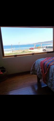 a bedroom with a window with a view of the beach at Casa playa ConCon in Concón